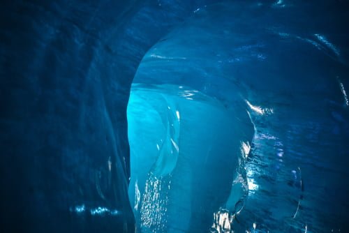 Blue ice cave of The Sea of Ice in Chamonix, France, flooded with light