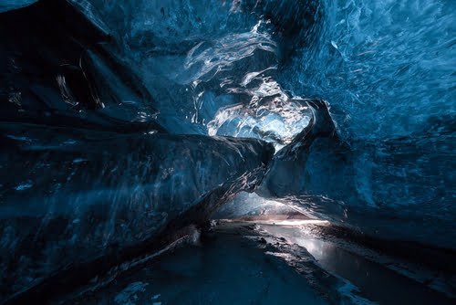 Wide angle shot inside an icecave in a glacier in Iceland, fantastic color and light, The cave is lit up by the sun shining on the glacier surface