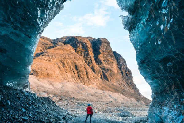 Solo female adventure traveler is discovering the ice caves in Iceland at Vatnajokull Glacier near to Jokulsarlon Glacier Lagoon. Tourism in abandoned Iceland . Outdoor living and exploring